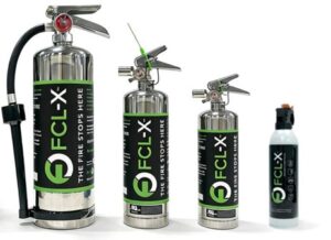Set of FCL-X fire extinguishers in different sizes with green labels and attached hoses, lined up on a white surface, plus a small container on the right.